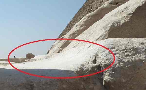 Detaliu al fațadei unei piramide, marcat cu un cerc roșu pentru a evidenția o formă specifică de eroziune verticală, sub formă de "jgheab". Această uzură este interpretată de unii cercetători ca fiind cauzată de ploi torențiale prelungite, dintr-o epocă mult mai veche decât cea a Regatului Vechi.