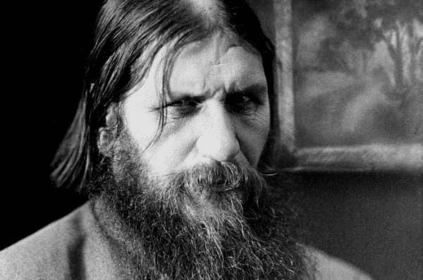 Călugărul siberian Grigori Rasputin cu o privire intensă, pătrunzătoare și barbă neagră, purtând o rasă simplă.